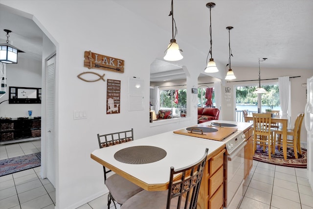491 Eastshore Rd, Newport, WA 99156 - kitchen with white range with electric stovetop, light tile patterned floors, hanging light fixtures, a center island, and lofted ceiling