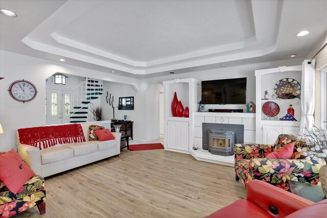 491 Eastshore Rd, Newport, WA 99156 - living area with a tray ceiling, recessed lighting, stairway, wood finished floors, and a wood stove