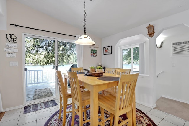 491 Eastshore Rd, Newport, WA 99156 - dining room featuring a wall mounted AC, vaulted ceiling, light tile patterned floors, and baseboards