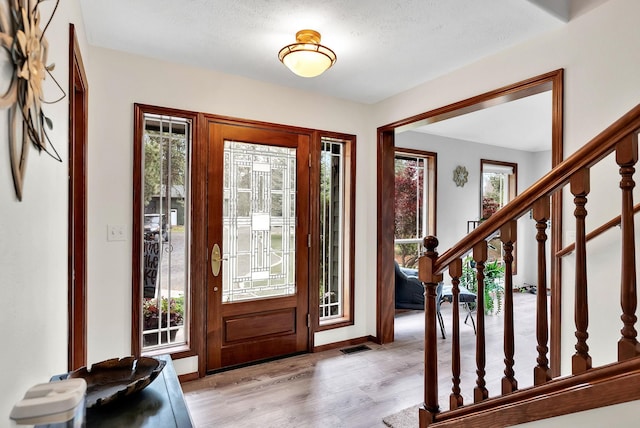 6533 D Lois Way, Nine Mile Falls, WA 99026 - foyer featuring light wood-style floors, baseboards, stairway, and a textured ceiling