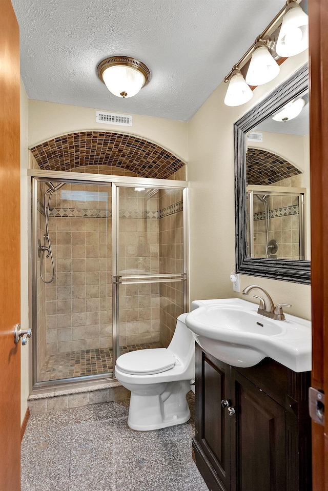 6533 D Lois Way, Nine Mile Falls, WA 99026 - bathroom with toilet, vanity, a shower stall, and a textured ceiling
