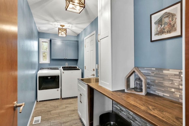 6533 D Lois Way, Nine Mile Falls, WA 99026 - laundry room featuring independent washer and dryer, cabinet space, and light wood-style floors