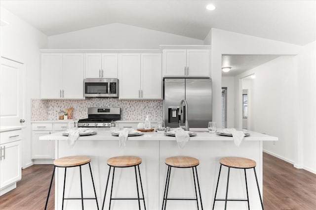 3105 N Rio Grande Rd, Spokane Valley, WA 99027 - kitchen featuring appliances with stainless steel finishes, lofted ceiling, a kitchen bar, white cabinets, and light wood-style floors