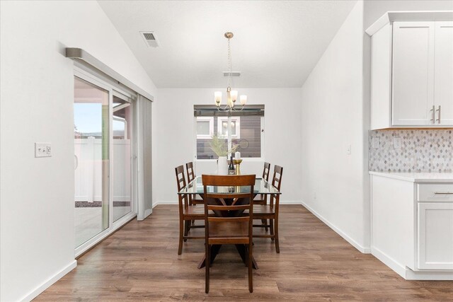 3105 N Rio Grande Rd, Spokane Valley, WA 99027 - dining area featuring a chandelier, wood finished floors, vaulted ceiling, and baseboards