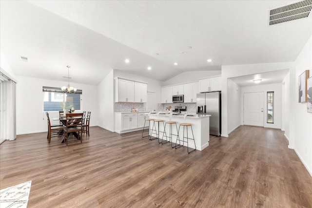 3105 N Rio Grande Rd, Spokane Valley, WA 99027 - kitchen featuring stainless steel appliances, lofted ceiling, a kitchen island with sink, a chandelier, and light countertops
