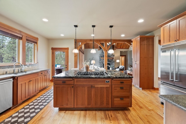 1122 E Hangman Ln, Spokane, WA 99224 - kitchen featuring appliances with stainless steel finishes, light wood-style flooring, recessed lighting, a sink, and dark stone countertops