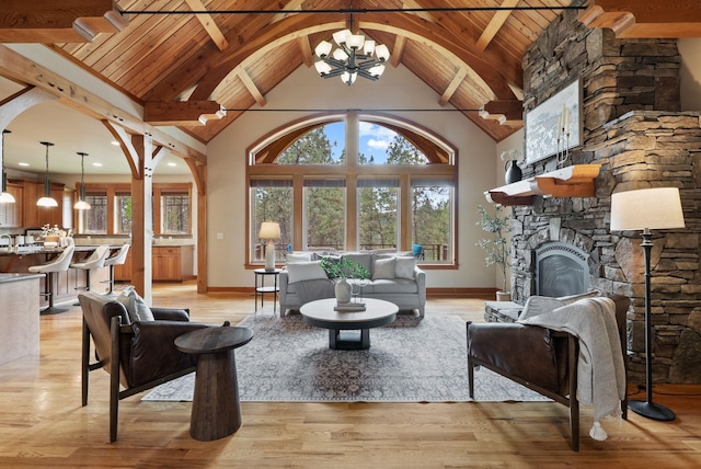 1122 E Hangman Ln, Spokane, WA 99224 - living area with a chandelier, a fireplace, wooden ceiling with exposed beams, plenty of natural light, and light wood-style floors