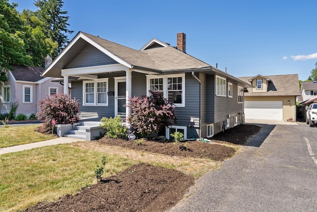 3507 E 28th Ave, Spokane, WA 99223 - view of front of property featuring covered porch, a chimney, a garage, driveway, and an outdoor structure