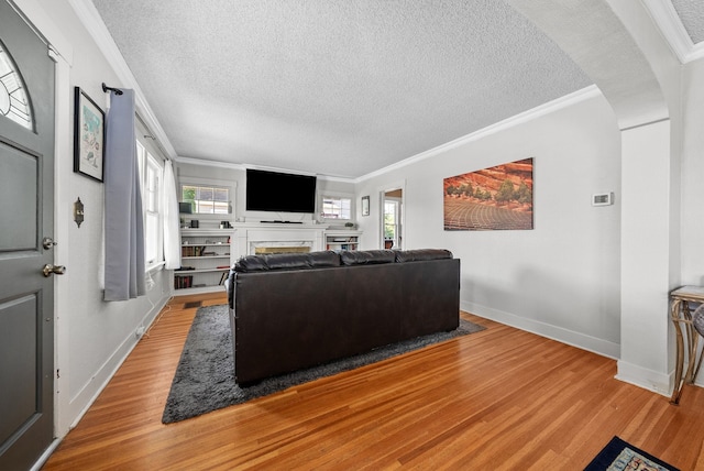 3507 E 28th Ave, Spokane, WA 99223 - living room featuring a textured ceiling, crown molding, light wood-type flooring, a fireplace, and baseboards