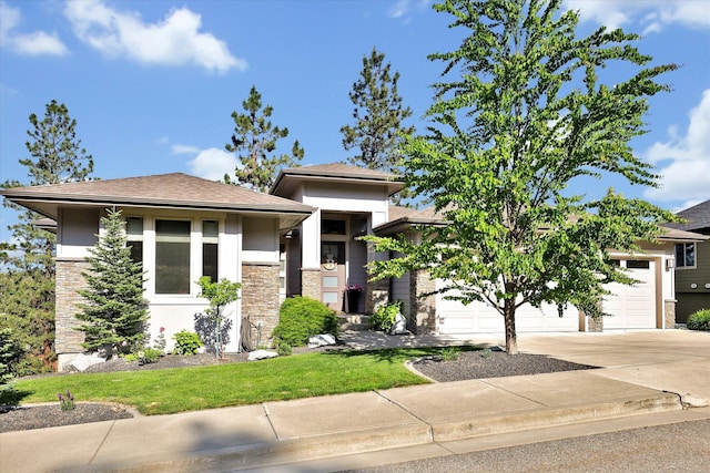 4523 S Henrys Fork Ln, Spokane, WA 99206 - prairie-style home featuring concrete driveway, stone siding, an attached garage, stucco siding, and a front lawn