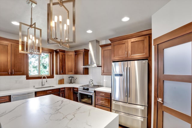 4523 S Henrys Fork Ln, Spokane, WA 99206 - kitchen featuring appliances with stainless steel finishes, wall chimney range hood, brown cabinetry, a chandelier, and tasteful backsplash