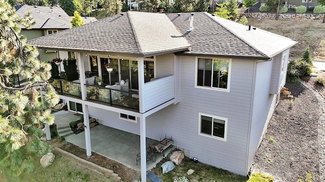 4523 S Henrys Fork Ln, Spokane, WA 99206 - rear view of property featuring roof with shingles, a patio, and a sunroom
