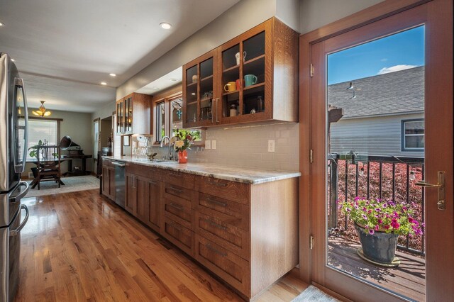 934 E 38th Ave, Spokane, WA 99203 - kitchen featuring stainless steel appliances, light wood-type flooring, glass insert cabinets, backsplash, and recessed lighting