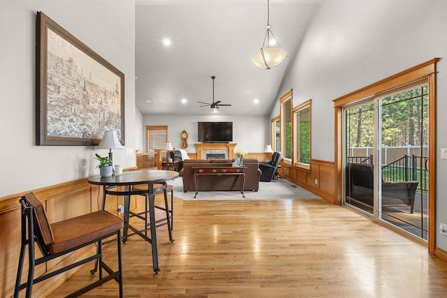 1220 E Fireside Ln, Spokane, WA 99208 - dining space featuring light wood finished floors, a ceiling fan, a wainscoted wall, high vaulted ceiling, and a fireplace