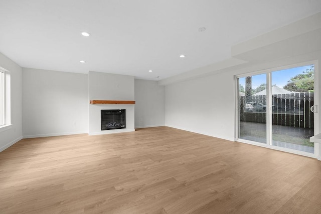 101 S W St, Chewelah, WA 99109 - unfurnished living room with light wood-style flooring, a fireplace, baseboards, and recessed lighting