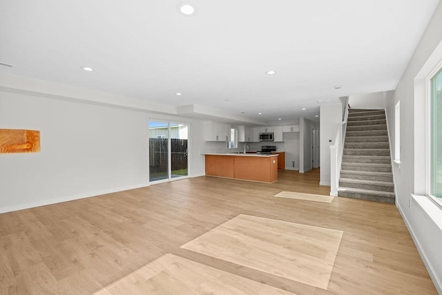 101 S W St, Chewelah, WA 99109 - unfurnished living room with stairs, baseboards, recessed lighting, and light wood-style flooring