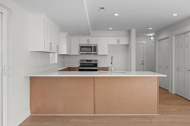 101 S W St, Chewelah, WA 99109 - kitchen featuring stainless steel appliances, a sink, light wood-style floors, a peninsula, and recessed lighting