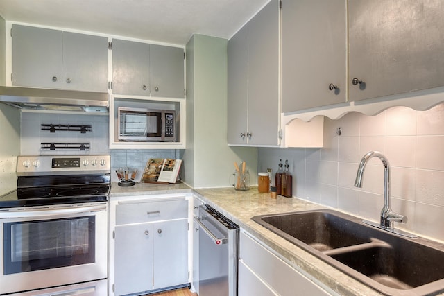 2729 W Broad Ave, Spokane, WA 99205 - kitchen with appliances with stainless steel finishes, ventilation hood, a sink, decorative backsplash, and light countertops