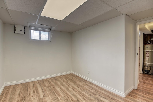 2729 W Broad Ave, Spokane, WA 99205 - below grade area featuring strapped water heater, a paneled ceiling, light wood-type flooring, and baseboards