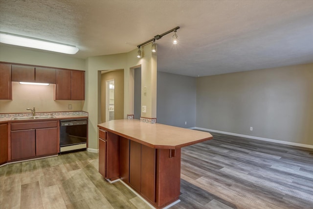 707 W 6th Ave # 33, Spokane, WA 99204 - kitchen with dishwasher, a sink, a peninsula, light countertops, and a textured ceiling