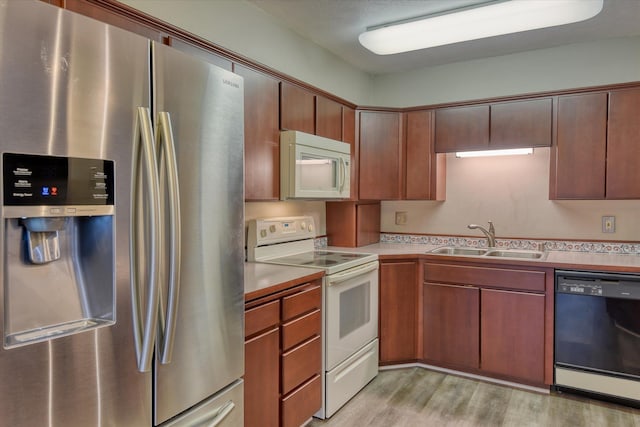 707 W 6th Ave # 33, Spokane, WA 99204 - kitchen with white appliances, a sink, light wood finished floors, and light countertops