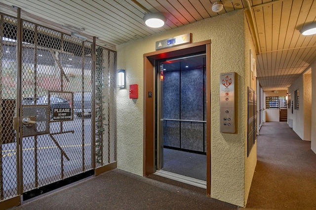 707 W 6th Ave # 33, Spokane, WA 99204 - doorway with a textured wall, carpet floors, elevator, wood ceiling, and healthy amount of natural light