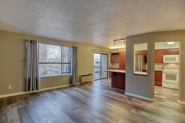 707 W 6th Ave # 33, Spokane, WA 99204 - kitchen featuring white appliances, light wood finished floors, light countertops, a textured ceiling, and baseboards