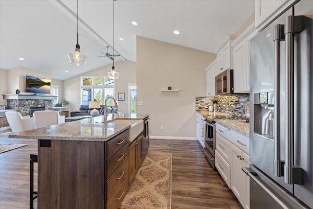 696 W Basalt Ridge Dr, Spokane, WA 99224 - kitchen with stainless steel appliances, a sink, a breakfast bar, vaulted ceiling, and tasteful backsplash