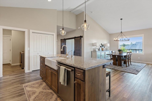 696 W Basalt Ridge Dr, Spokane, WA 99224 - kitchen with stainless steel dishwasher, a sink, high vaulted ceiling, a barn door, and baseboards
