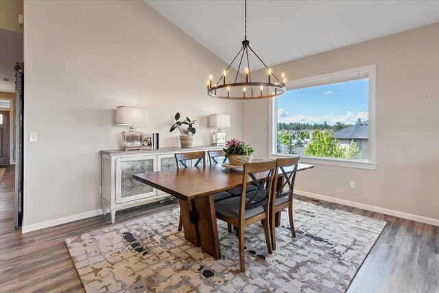 696 W Basalt Ridge Dr, Spokane, WA 99224 - dining space featuring a chandelier, wood finished floors, baseboards, and high vaulted ceiling