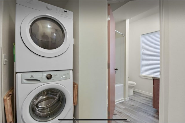 1702 W Dean Ave, Spokane, WA 99201 - laundry area featuring estacked washer and dryer, light wood finished floors, and baseboards