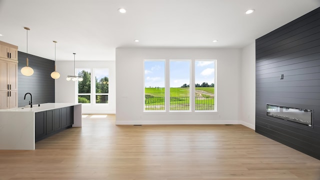 8521 W Dahl Rd, Deer Park, WA 99006 - unfurnished living room with healthy amount of natural light, wood walls, light wood-style floors, recessed lighting, and baseboards