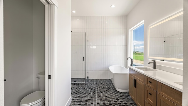 8521 W Dahl Rd, Deer Park, WA 99006 - bathroom featuring a freestanding bath, a stall shower, double vanity, toilet, and tile patterned flooring
