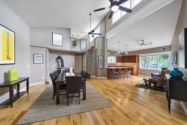 21123 S Cheney Spangle Rd, Cheney, WA 99004 - dining room with a wood stove, ceiling fan, high vaulted ceiling, light wood finished floors, and baseboards
