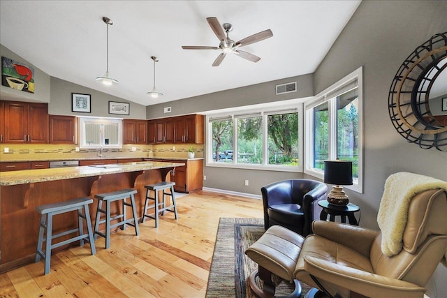 21123 S Cheney Spangle Rd, Cheney, WA 99004 - kitchen featuring light wood-type flooring, lofted ceiling, a kitchen bar, backsplash, and a sink