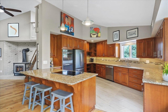 21123 S Cheney Spangle Rd, Cheney, WA 99004 - kitchen featuring appliances with stainless steel finishes, a sink, a peninsula, high vaulted ceiling, and a wood stove