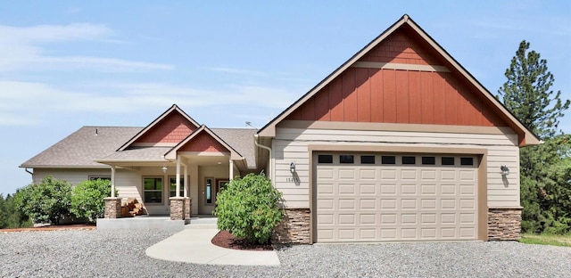15415 E Timbercrest Ln, Mead, WA 99021 - craftsman-style home featuring stone siding, a garage, driveway, roof with shingles, and covered porch