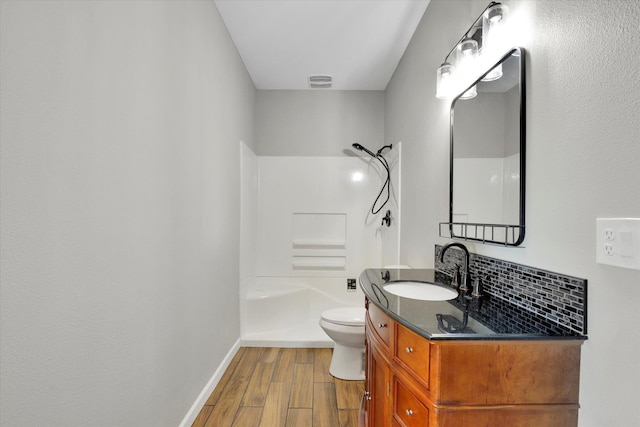 15415 E Timbercrest Ln, Mead, WA 99021 - bathroom with vanity, wood finished floors, toilet, washtub / shower combination, and baseboards