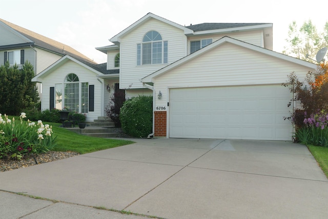 6706 S Moran View St, Spokane, WA 99224 - view of front facade with driveway, a front yard, brick siding, and a garage