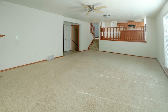 6706 S Moran View St, Spokane, WA 99224 - unfurnished living room featuring a ceiling fan, light colored carpet, stairway, and baseboards