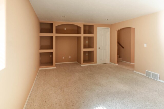 6706 S Moran View St, Spokane, WA 99224 - empty room with carpet floors, baseboards, arched walkways, and stairs