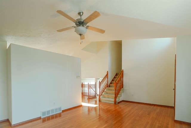 6706 S Moran View St, Spokane, WA 99224 - spare room featuring lofted ceiling, wood finished floors, baseboards, ceiling fan, and stairway