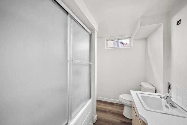 2603 E Wellesley Ave, Spokane, WA 99217 - bathroom featuring toilet, vanity, wood finished floors, enclosed tub / shower combo, and baseboards
