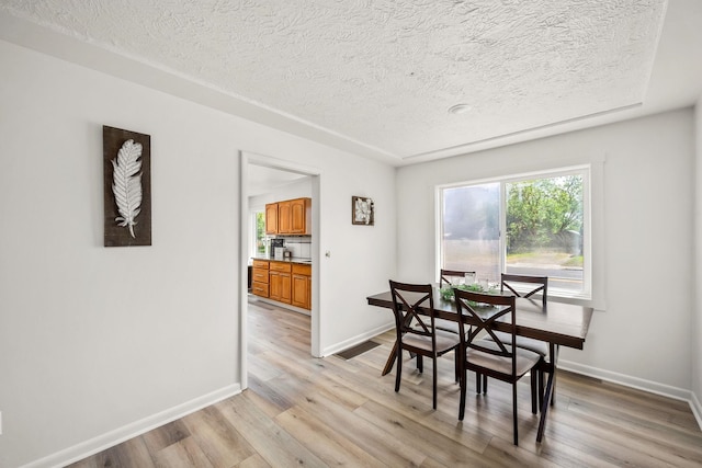 2603 E Wellesley Ave, Spokane, WA 99217 - dining space with a textured ceiling, light wood finished floors, and baseboards