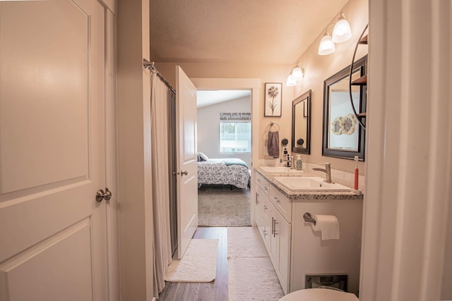 3414 N Lee St, Spokane, WA 99207 - full bath featuring double vanity, ensuite bath, vaulted ceiling, and a textured ceiling