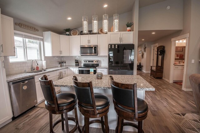 3414 N Lee St, Spokane, WA 99207 - kitchen with appliances with stainless steel finishes, a sink, lofted ceiling, a center island, and backsplash