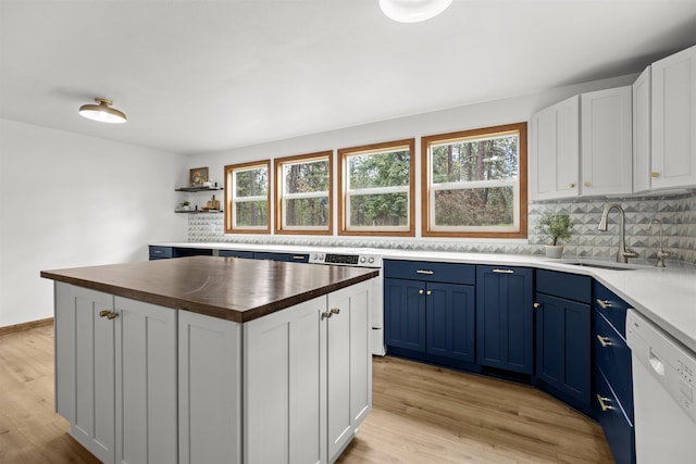 12411 E Gibbs Rd, Mica, WA 99023 - kitchen with blue cabinetry, dishwasher, a sink, and plenty of natural light