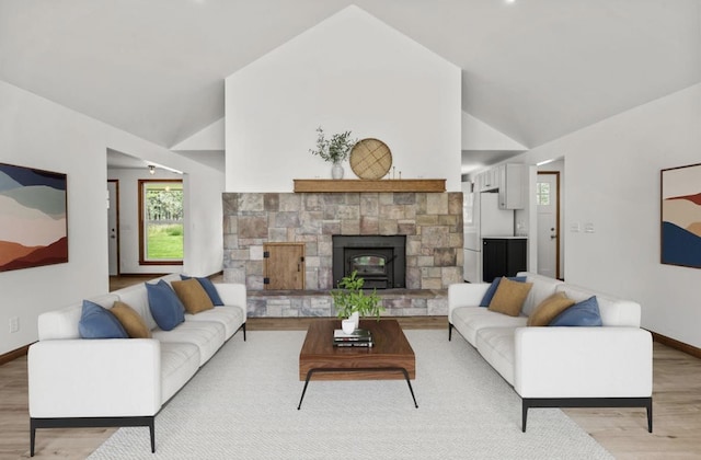12411 E Gibbs Rd, Mica, WA 99023 - living room featuring light wood finished floors, baseboards, a stone fireplace, and high vaulted ceiling