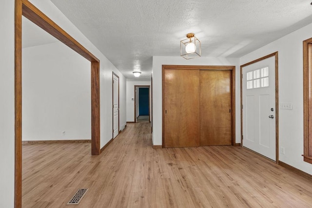 12411 E Gibbs Rd, Mica, WA 99023 - entrance foyer featuring light wood-style flooring, baseboards, and a textured ceiling