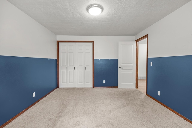 12411 E Gibbs Rd, Mica, WA 99023 - unfurnished bedroom featuring a closet, baseboards, a textured ceiling, and carpet floors